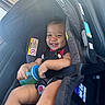 baby, car_seat, child, clothing, cute, hair, happy, holding, infant, interior, person, safety, seat, seatbelt, sippy_cup, skin, smiling, toddler, transportation, vehicle