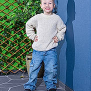 Nixon joined the competition — help win amazing prizes! child, boy, smiling, sweater, jeans, shoes, shadow, wall, plant, trellis, outdoor, floor, patterned_floor, confident, happy, casual_clothing, portrait, posing, greenery, daylight