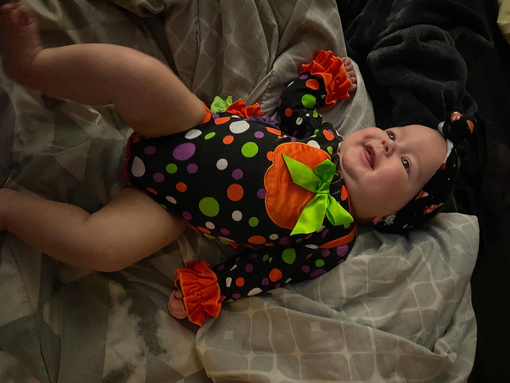Evalynn is registered to the contest to win money with this photo: arm, baby, baby_products, baby_toddler_clothing, child, comfort, fun, happy, headwear, human_leg, linens, nail, orange, pattern, person, play, room, sitting, sleeve, textile