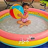 child, pool, beach_ball, hammock, chair, sandals, outdoor, smile, water, play, toy, colorful, happy, summer, relaxation, grass, fence, footwear, person, tarp
