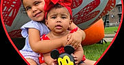 Emiely is registered to the contest to win money with this photo: baby, child, children, cute, family, grass, happy, headband, heart_frame, hugging, outdoor, park, playful, portrait, purple_clothing, red_clothing, sitting, smiling, summer, toy