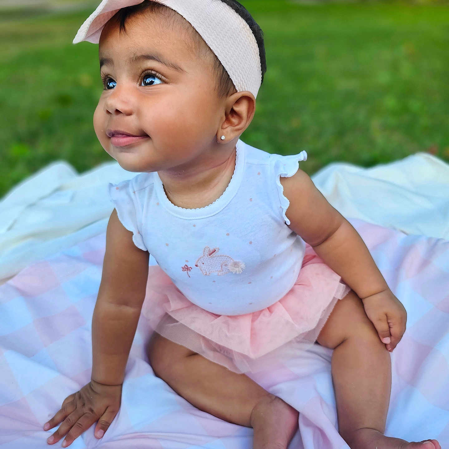 Emiely is registered to the contest to win money with this photo: baby, child, outdoor, grass, blanket, headband, bow, pink, white, tutu, cute, smiling, portrait, sitting, toddler, person, happy, fashion, nature, eyewear