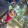 dog, person, outdoor, smile, harness, tree, grass, sunlight, sidewalk, happy, nature, canine, casual_clothing, park, daytime, leash, animal, pet, portrait, human