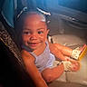 toddler, child, smiling, car_seat, moccasin_shoes, pigtails, happy, indoors, seat, baby, person, cute, portrait, clothing, footwear, young_child, car_interior, skin, head, face