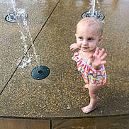 Jalice joined the competition — help win amazing prizes! toddler, child, water_fountain, play, swimsuit, barefoot, outdoor, water, fun, summer, curious, wet_surface, colorful, young_child, reaching, happy, park, fountain, playground, daytime