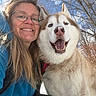 blue_jacket, canine, closeup, daylight, dog, friendship, fur, glasses, happy, husky, nature, outdoor, pet, portrait, sky, smiling, snow, tree, winter, woman