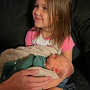 Leilani is registered to the contest to win money with this photo: child, baby, newborn, girl, smile, blanket, hand, couch, indoor, person, sleeping, holding, family, cozy, clothing, young, portrait, happy, care, love