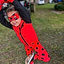 Leilani joined the competition — help win amazing prizes! child, costume, red, black, mask, gloves, outdoor, grass, playful, pose, smile, shoes, superhero, dots, fun, person, young, parked_cars, daylight, happy