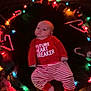 baby, infant, christmas_lights, candy_cane, festive_clothing, red_shirt, striped_pajamas, holiday, decorations, colorful_lights, floor, celebration, cute, child, lying_down, soft_lighting, indoors, festive, christmas, toddler