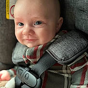 Jayce joined the competition — help win amazing prizes! baby, infant, smile, car_seat, child, plaid_clothing, straps, close_up, face, blue_eyes, cute, indoors, seatbelt, young_child, portrait, child_seat, apparel, fabric, comfort, safety