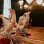 Svetlana is registered to the contest to win money with this photo: child, toddler, mirror, reflection, dress, red_bow, golden_flower, crown, hands_up, indoor, chandelier, elegant_room, wooden_floor, portrait, happy, cute, celebration, smile, baby, luxury