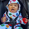 baby, baby_clothes, cartoon, child, clothing, colorful_clothing, cute, happy, hoodie, infant, mickey_mouse, outdoor, pattern, person, playful, seatbelt, seated, smiling, stroller, young