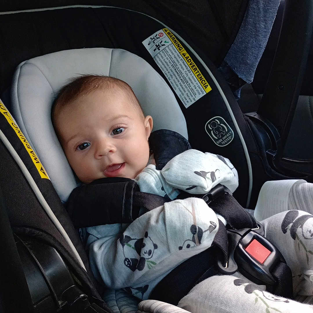 Alice is registered to the contest to win money with this photo: baby, car_seat, pajamas, panda_print, smiling, infant, seatbelt, child, safety, cute, indoors, clothing, seat, restraint, car_interior, person, young_child, portrait, baby_clothes, comfort