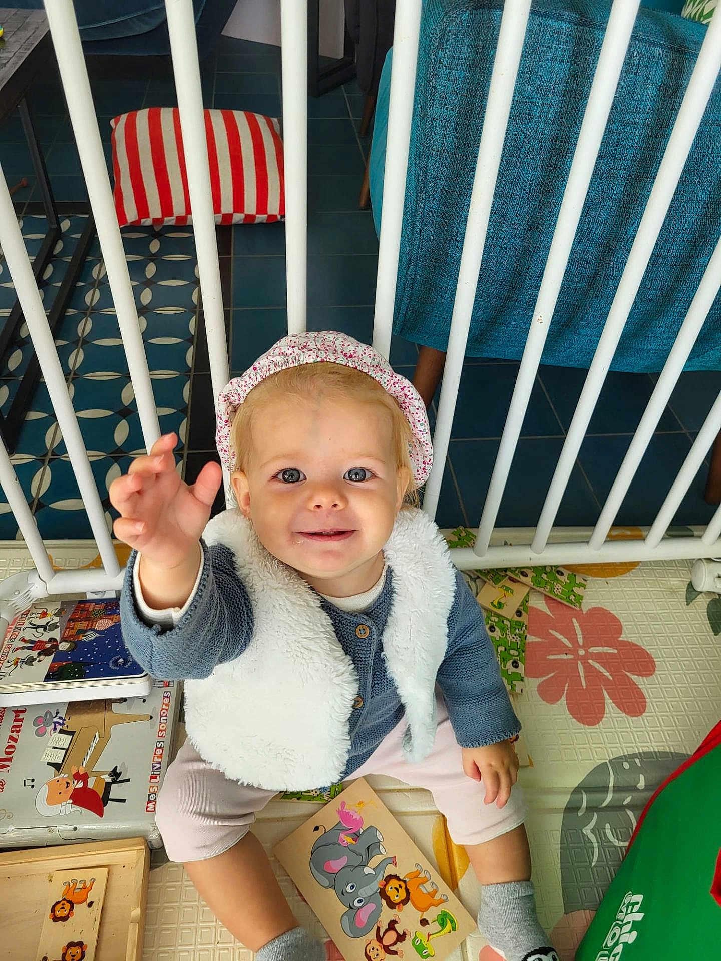 Chjara participe au concours pour gagner de l'argent avec cette photo : toddler, child, smiling, indoor, playmat, toys, books, vest, headband, socks, floor, colorful, baby, furniture, safety_bars, happy, cute, person, reaching, seated