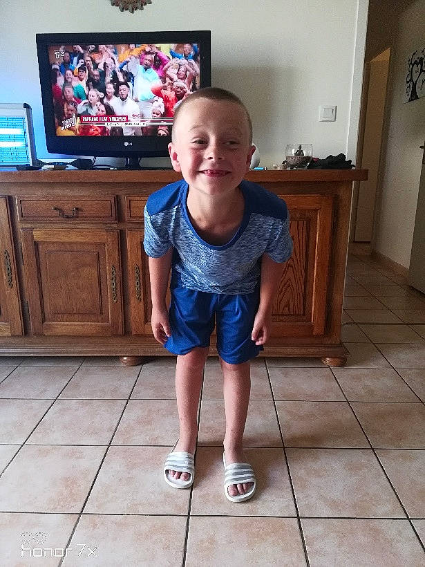 Antonin participe au concours pour gagner de l'argent avec cette photo : blurred, display_device, electric_blue, flat_panel_display, floor, flooring, fun, happy, hardwood, human_leg, joy, knee, leg, leisure, person, smile, standing, television, television_set, thigh