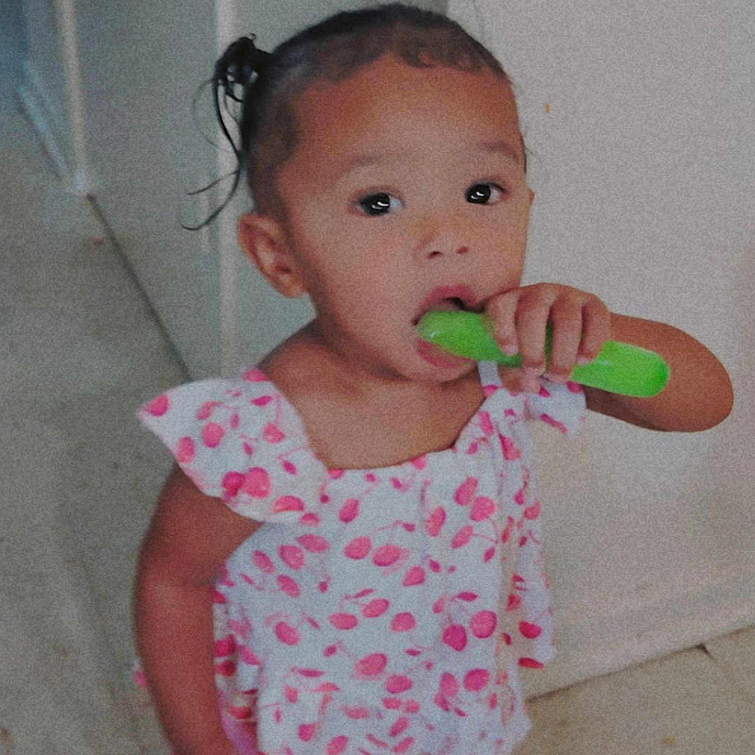 Tru'Melody is registered to the contest to win money with this photo: barefoot, casual, child, curly_hair, cute, doorway, floor, food, indoors, person, pink_clothing, playful, popsicle, portrait, snack, standing, summer_treat, toddler, wall, young_child