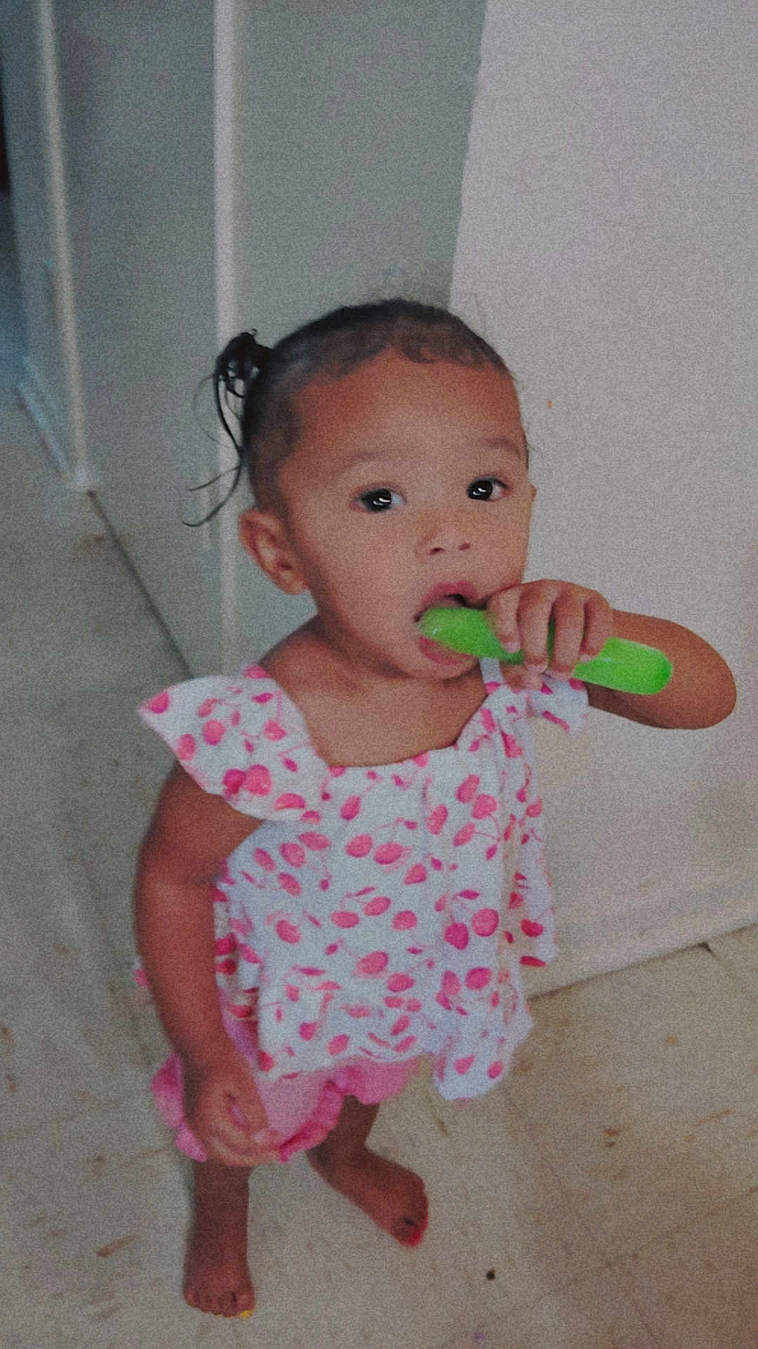 Tru'Melody is registered to the contest to win money with this photo: toddler, child, indoors, barefoot, pink_clothing, popsicle, food, curly_hair, standing, floor, cute, young_child, person, playful, summer_treat, snack, wall, doorway, portrait, casual