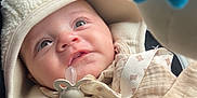 Athyr participe au concours pour gagner de l'argent avec cette photo : baby, infant, pacifier, hood, jacket, clothing, toy, blue, curious, face, child, seatbelt, car_seat, closeup, warm, soft, indoor, expression, cute, portrait