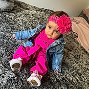 Layla joined the competition — help win amazing prizes! baby, child, denim_jacket, pink_outfit, headband, flower, white_shoes, blanket, bed, fur_texture, cute, indoor, portrait, infant, clothing, sitting, person, fashion, expression, home