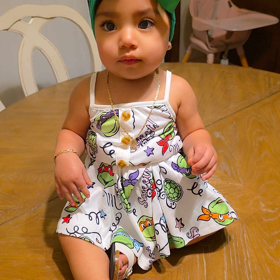 Jaylah Marquez joined the competition — help win amazing prizes! accessories, baby, bodypart, bonnet, clothing, dress, face, finger, footwear, hardwood, hat, head, jewelry, necklace, person, plywood, sandal, shoe, sitting, wood