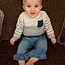toddler, child, baby, sitting, couch, clothing, sweater, denim, pants, barefoot, face, smile, drool, indoor, furniture, young_child, portrait, casual, striped, comfortable