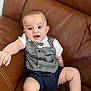 Muhammed joined the competition — help win amazing prizes! baby, infant, child, couch, leather, clothing, vest, bow_tie, shorts, sneakers, person, sitting, furniture, indoor, expression, reaching, cute, small, happy, face
