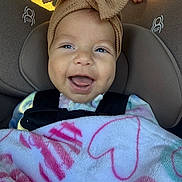 Mackenzie joined the competition — help win amazing prizes! baby, smiling, car_seat, headband, bow, blanket, heart_pattern, child, happy, infant, closeup, face, person, seatbelt, cute, indoors, toddler, apparel, childhood, portrait