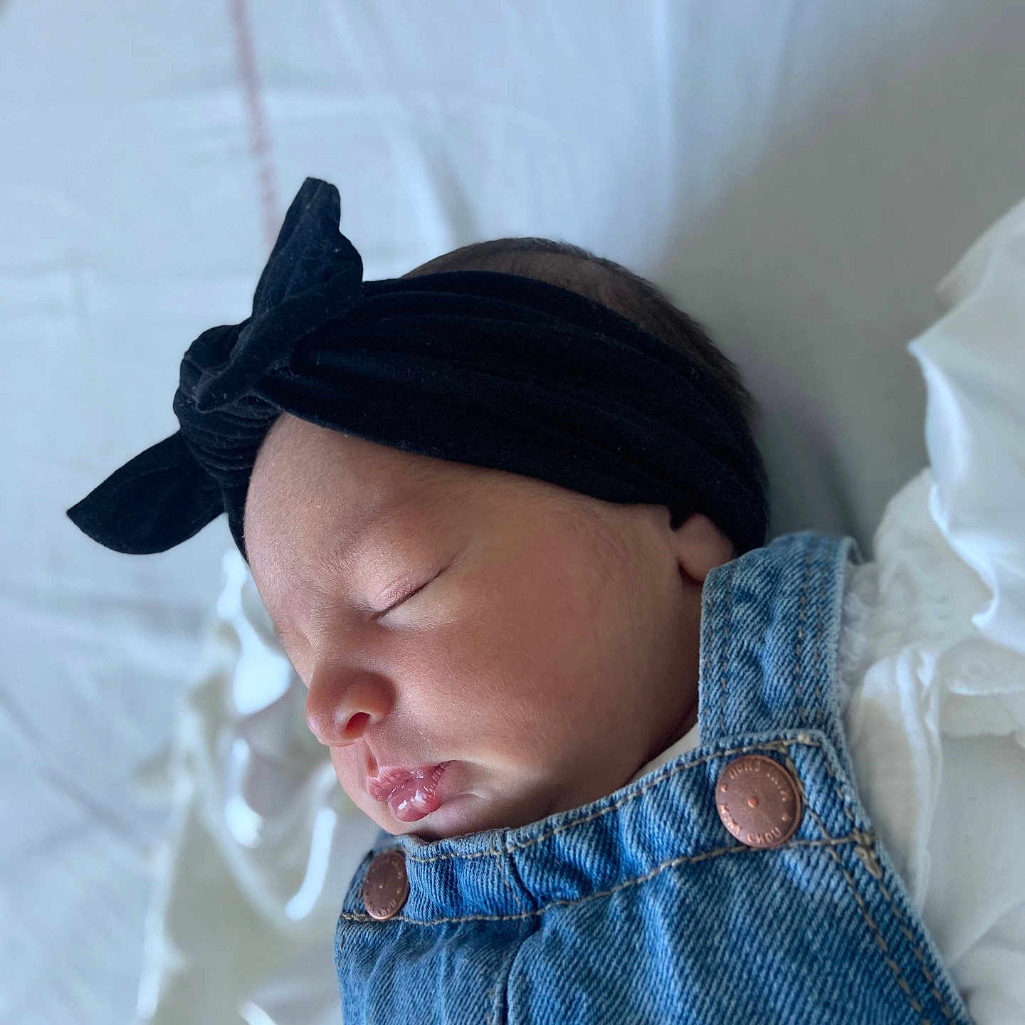 Naïsmée a rejoint le concours — aidez-le/la à gagner de superbes lots ! baby, baby_girl, black, closeup, clothing, cozy, cute, denim, face, headband, infant, newborn, peaceful, portrait, resting, skin, sleeping, soft_light, toddler, white_blanket