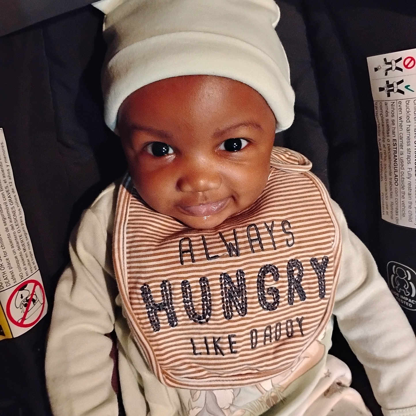 Bradley joined the competition — help win amazing prizes! baby, infant, child, smiling, bib, hat, white_hat, car_seat, safety_labels, clothing, cute, portrait, indoors, happy, young_child, baby_clothes, cheeky_smile, headwear, sitting, closeup