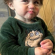 Giovanni joined the competition — help win amazing prizes! toddler, child, smirk, green_sweater, monster_patch, blanket, indoor, portrait, cute, funny_expression, person, baby, seated, face, hair, long_sleeves, cozy, soft_texture, playpen, casual
