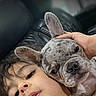 Stich is registered to the contest to win money with this photo: child, dog, french_bulldog, pet, couch, leather, face, snuggle, close_up, indoor, young, cute, portrait, notification, lock_screen, hand, skin, expression, relax, technology