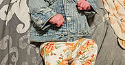 Estella is registered to the contest to win money with this photo: baby, infant, denim_jacket, floral_pants, headband, smile, happy, lying_down, bedspread, patterned_bedspread, barefoot, cute, child, young, indoor, person, clothing, fabric, joyful, relaxed
