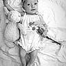 Estella joined the competition — help win amazing prizes! baby, infant, plush_toy, flower, headband, romper, blanket, black_and_white, cute, soft_texture, lying_down, child, adorable, smiling, portrait, toddler, hand, foot, innocence, young_child