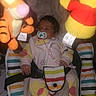 baby, pacifier, plush_toy, tigger, winnie_the_pooh, baby_seat, striped_pattern, blanket, child, infant, clothing, soft_toys, indoor, cute, comfort, seat_belt, pink, yellow, red, person