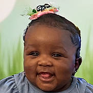 Halo joined the competition — help win amazing prizes! baby, child, smiling, headband, flower, blue_shirt, text_on_clothing, carrot_pattern, fabric, face, portrait, cute, happy, infant, sitting, background_blur, green_background, skin, clothing, person
