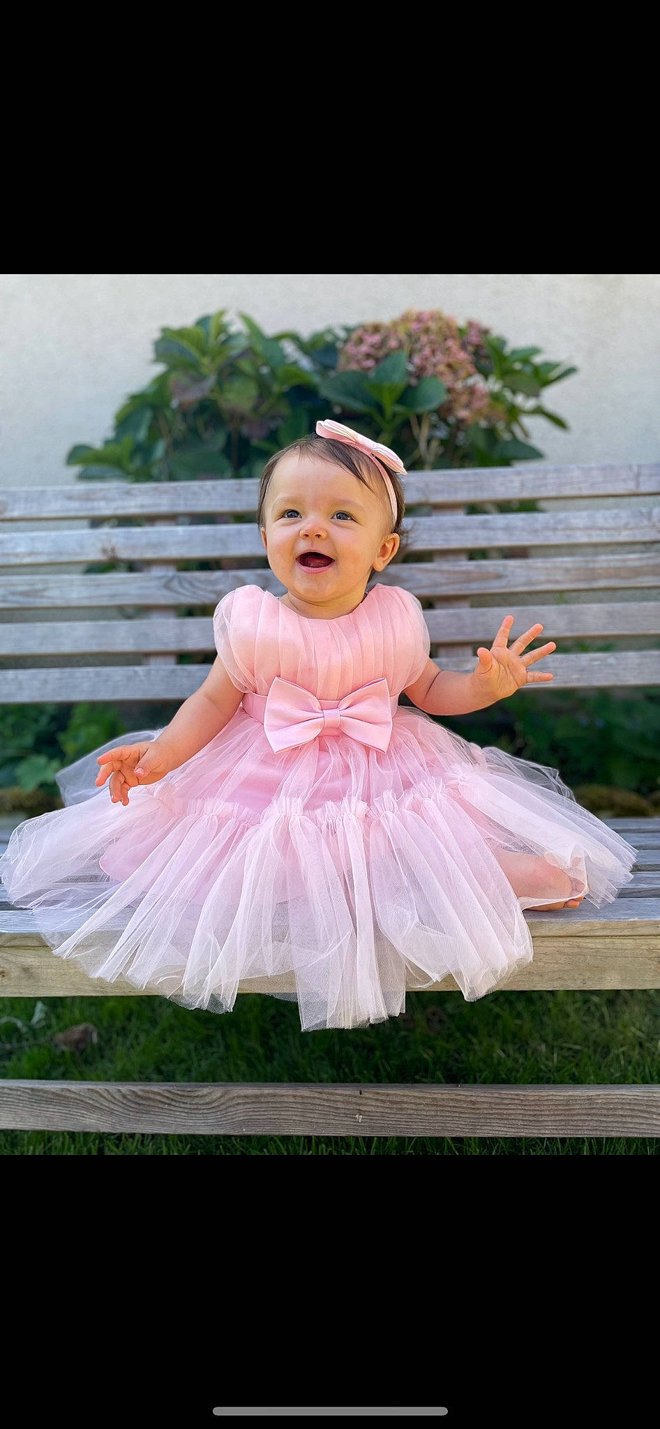 Taïna a rejoint le concours — aidez-le/la à gagner de superbes lots ! baby, baby_toddler_clothing, child, dress, embellishment, event, fashion_accessory, flash_photography, fun, grass, happy, headpiece, magenta, person, petal, pink, plant, ruffle, sleeve, smile