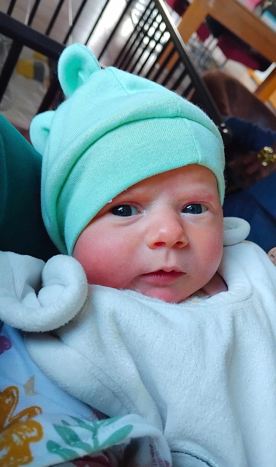 Rose a rejoint le concours — aidez-le/la à gagner de superbes lots ! baby, infant, hat, mint_green, blanket, face, blue_eyes, clothing, indoors, portrait, cute, newborn, warm, soft, person, headwear, expression, closeup, resting, cozy