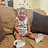 Jae'Onti is registered to the contest to win money with this photo: baby, child, smile, couch, indoor, pink_outfit, blue_sandals, bow, happy, infant, portrait, living_room, pillow, furniture, cute, seated, young_child, home, person, casual