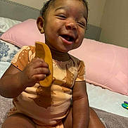 Jae'Onti joined the competition — help win amazing prizes! baby, child, smiling, comb, bed, pillow, onesie, orange_clothing, bow, curly_hair, happy, indoor, person, cute, infant, skin, hand, sitting, toy, playful