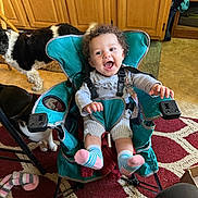 Destinee is registered to the contest to win money with this photo: animal, baby, baby_chair, carpet, child, curly_hair, cute, dog, floor, furniture, happy, home, indoor, person, pet, playful, smiling, socks, toddler, wooden_cabinets