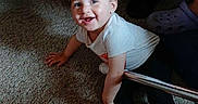 Destinee is registered to the contest to win money with this photo: toddler, child, smiling, curly_hair, crawling, carpet, indoors, blankets, chair, clothing, shoes, person, happy, home, floor, casual, cute, young_child, baby, light