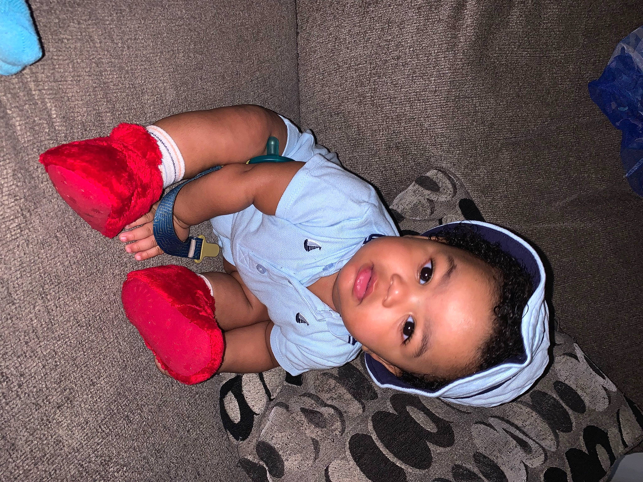 Kaston is registered to the contest to win money with this photo: baby, baby_toddler_clothing, child, comfort, flooring, foot, fun, hat, human_leg, joint, knee, lap, leg, mouth, person, shorts, sitting, smile, sock, thigh