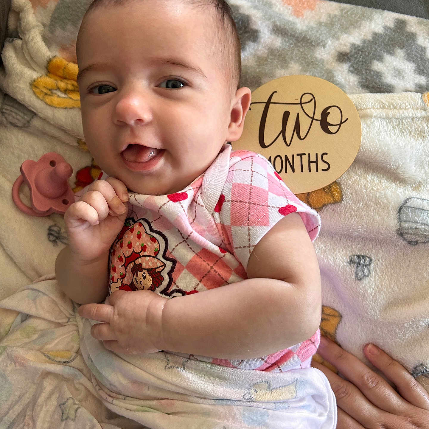 Arielle joined the competition — help win amazing prizes! baby, infant, two_months, blanket, pacifier, pink_clothing, cute, smiling, face, hand, lying_down, cozy, soft_toys, patterned_clothing, newborn, portrait, child, person, indoors, cute_face