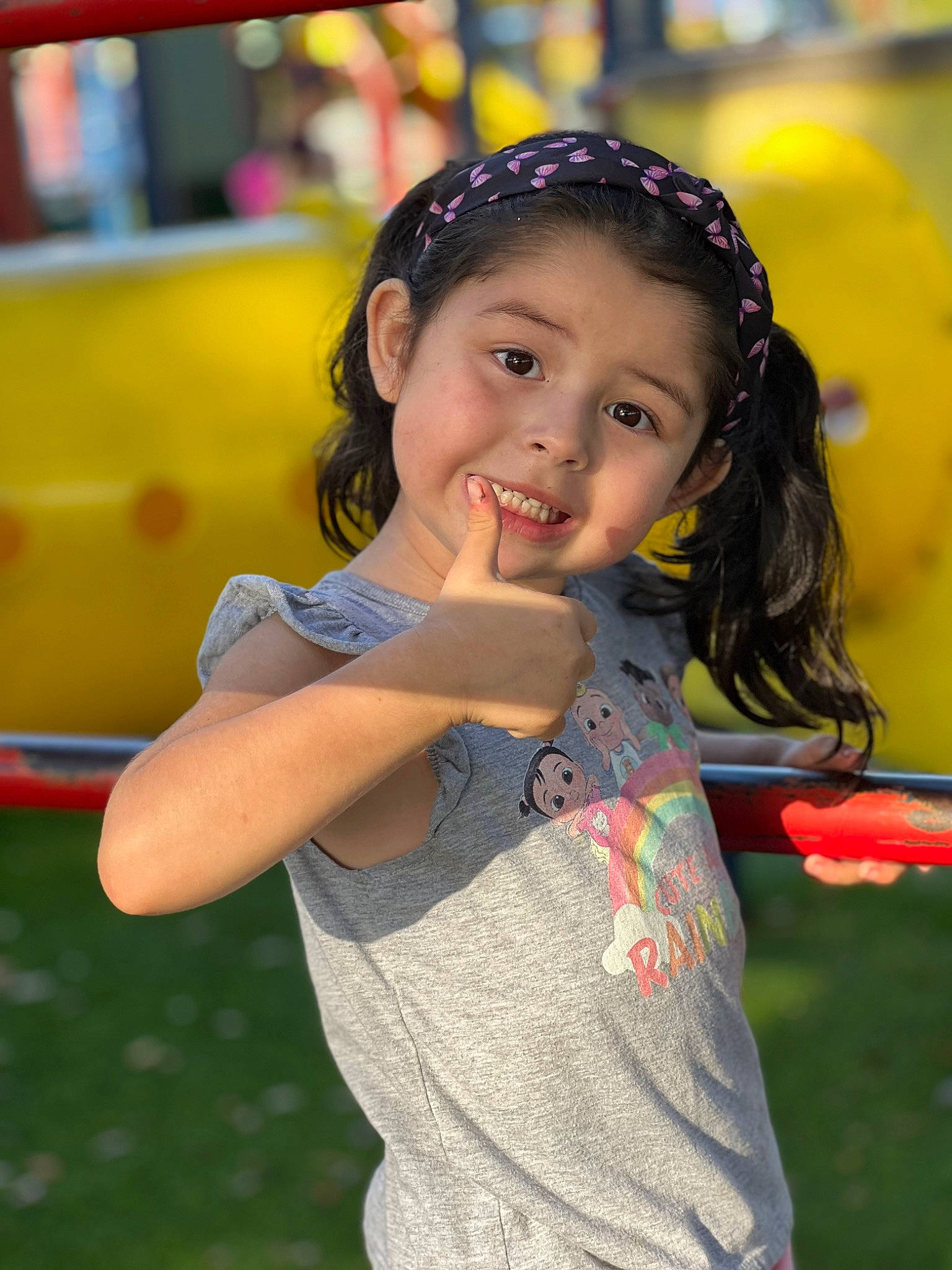 Alayah is registered to the contest to win money with this photo: audio_equipment, child, city, fun, grass, happy, joy, leisure, outdoor_play_equipment, person, play, playground, portrait_photography, recreation, smile, summer, t_shirt, toddler, vacation, yellow