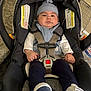 Ryan joined the competition — help win amazing prizes! baby, car_seat, infant, hat, clothing, straps, safety, indoor, carrying_handle, footwear, blanket, expression, person, seat_belt, cushion, child, face, hand, floor, wall