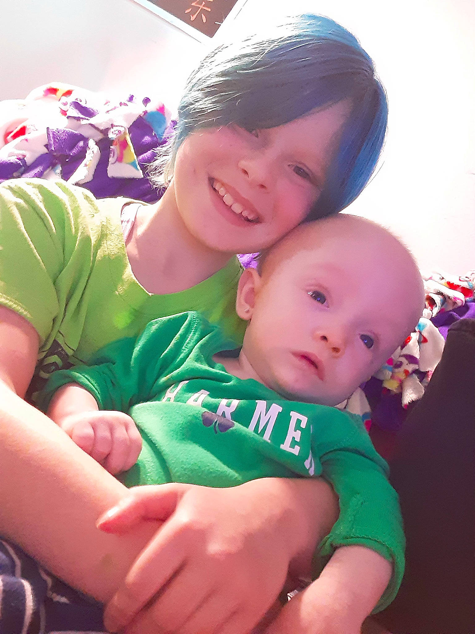 Skye is registered to the contest to win money with this photo: baby, baby_toddler_clothing, child, event, facial_expression, finger, fun, gesture, grass, hand, happy, joy, lap, mammal, person, pink, sitting, skin, sleeve, smile