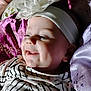 baby, baby_girl, child, closeup, cushion, cute, embroidery, face, flower, happy, headband, indoors, infant, joyful, person, portrait, purple_cushion, smiling, soft_lighting, striped_clothing