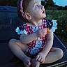 toddler, child, outdoor, evening, blue_sky, red_headband, patterned_clothing, sitting, curious, nature, grass, trees, portrait, cross_legged, cute, young_child, headband, face, person, casual