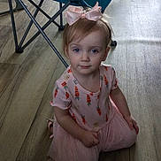 Maliza is registered to the contest to win money with this photo: toddler, girl, child, pink_dress, bow, kneeling, wooden_floor, indoor, blue_chair, folding_chair, carrot_pattern, clothing, flooring, person, headwear, young_child, room, casual, cute, portrait