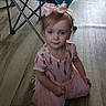 blue_chair, bow, carrot_pattern, casual, child, clothing, cute, flooring, folding_chair, girl, headwear, indoor, kneeling, person, pink_dress, portrait, room, toddler, wooden_floor, young_child